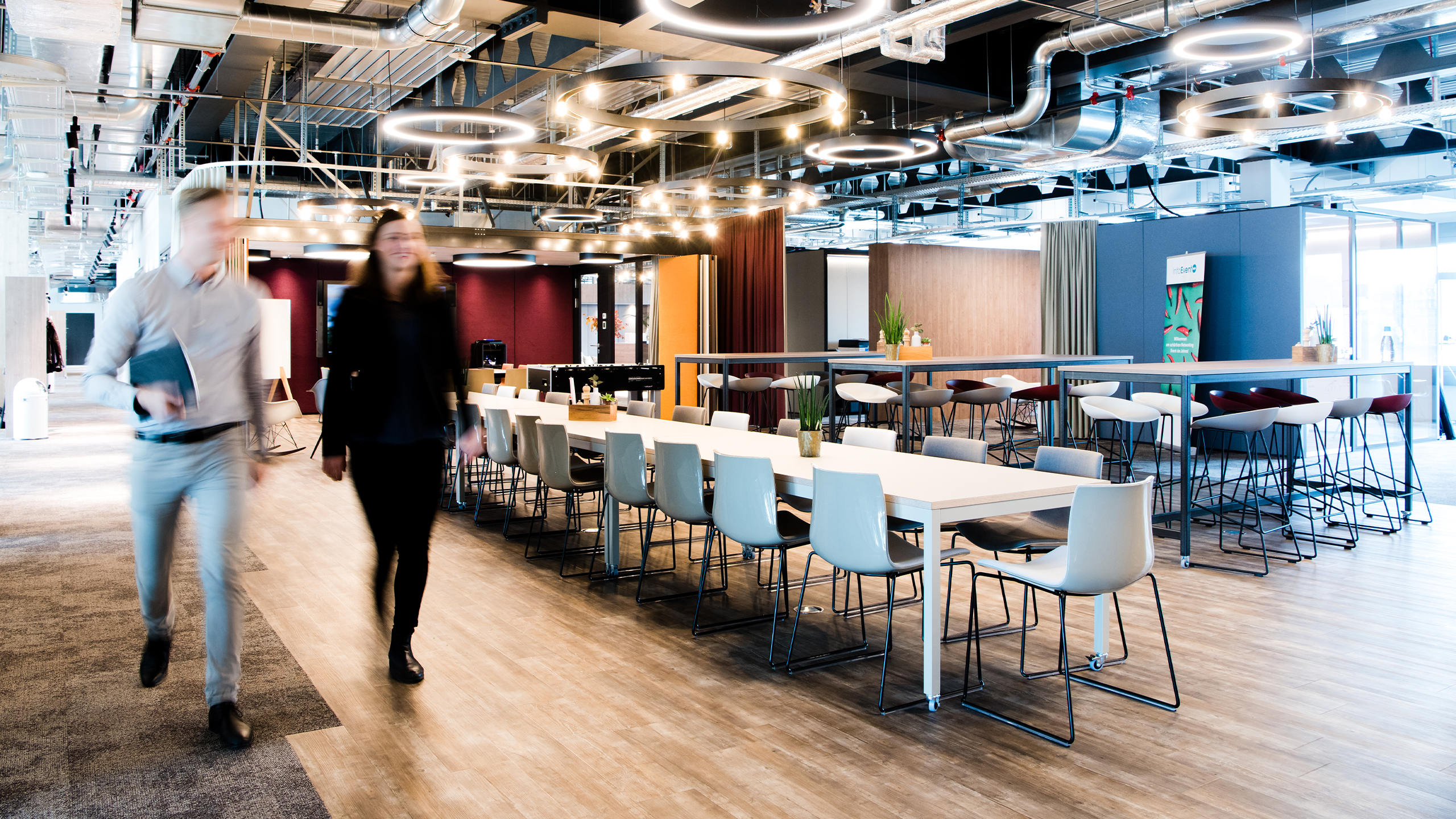 Begegnungsraum eines Grossraumsbüros mit vielen Tischen und Stühlen