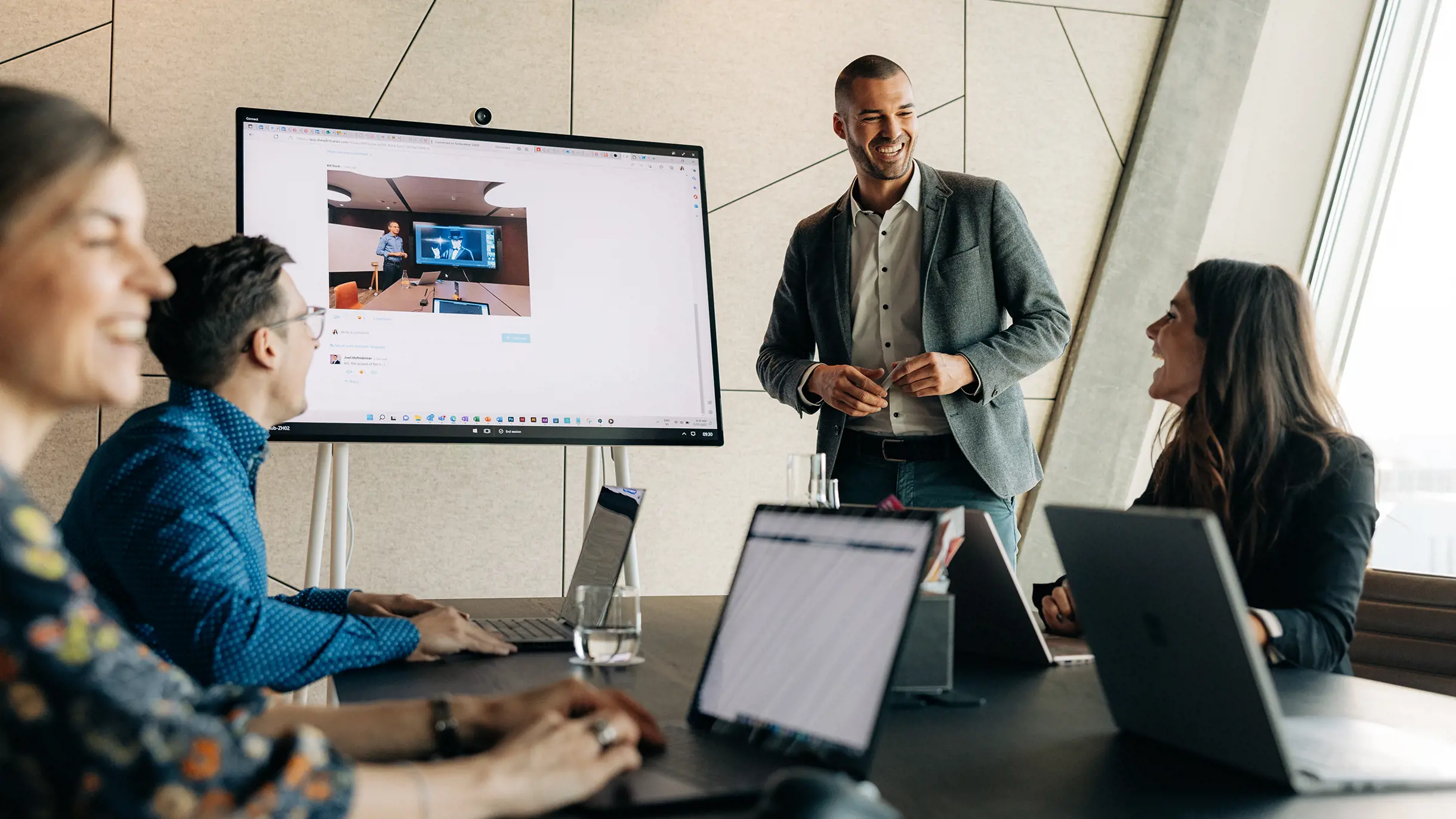 4 Personen in einem Sitzungszimmer lachend miteinander am arbeiten